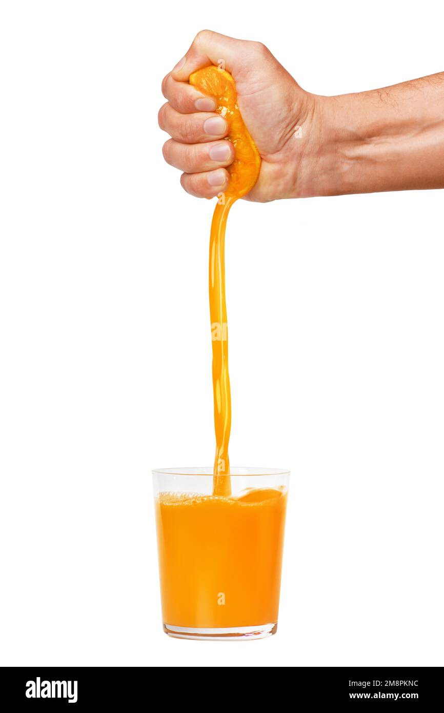 La main d'un homme presse une orange mûre dans un verre. Un homme tient et pince une orange. Le jus d'orange est en cours de versement. Isolé sur un fond blanc. Banque D'Images