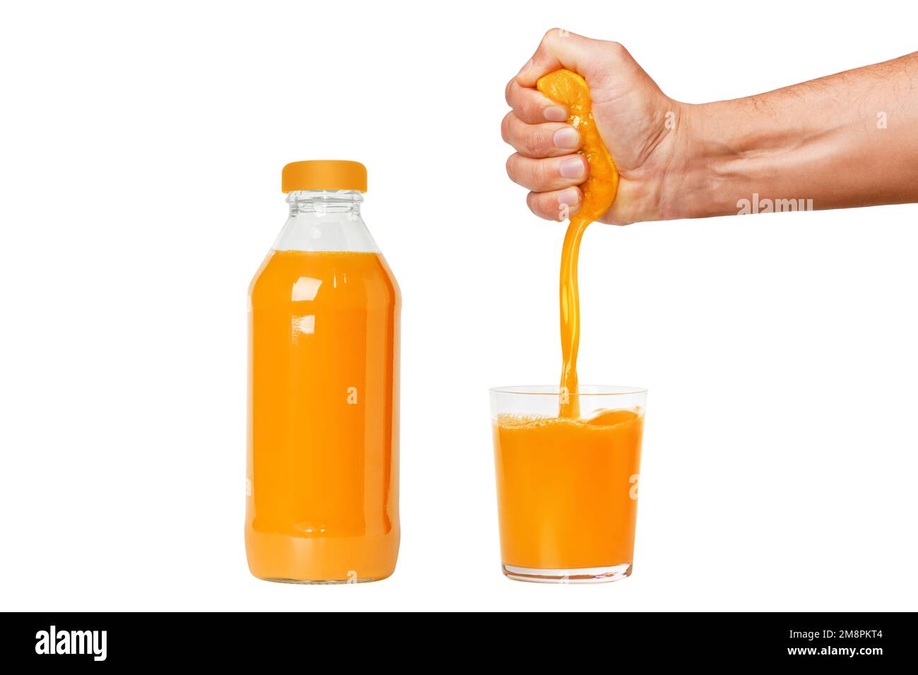 La main d'un homme presse une orange mûre dans un verre. Un homme tient et pince une orange. Le jus d'orange est en cours de versement. Bouteille d'oran fraîchement pressé Banque D'Images