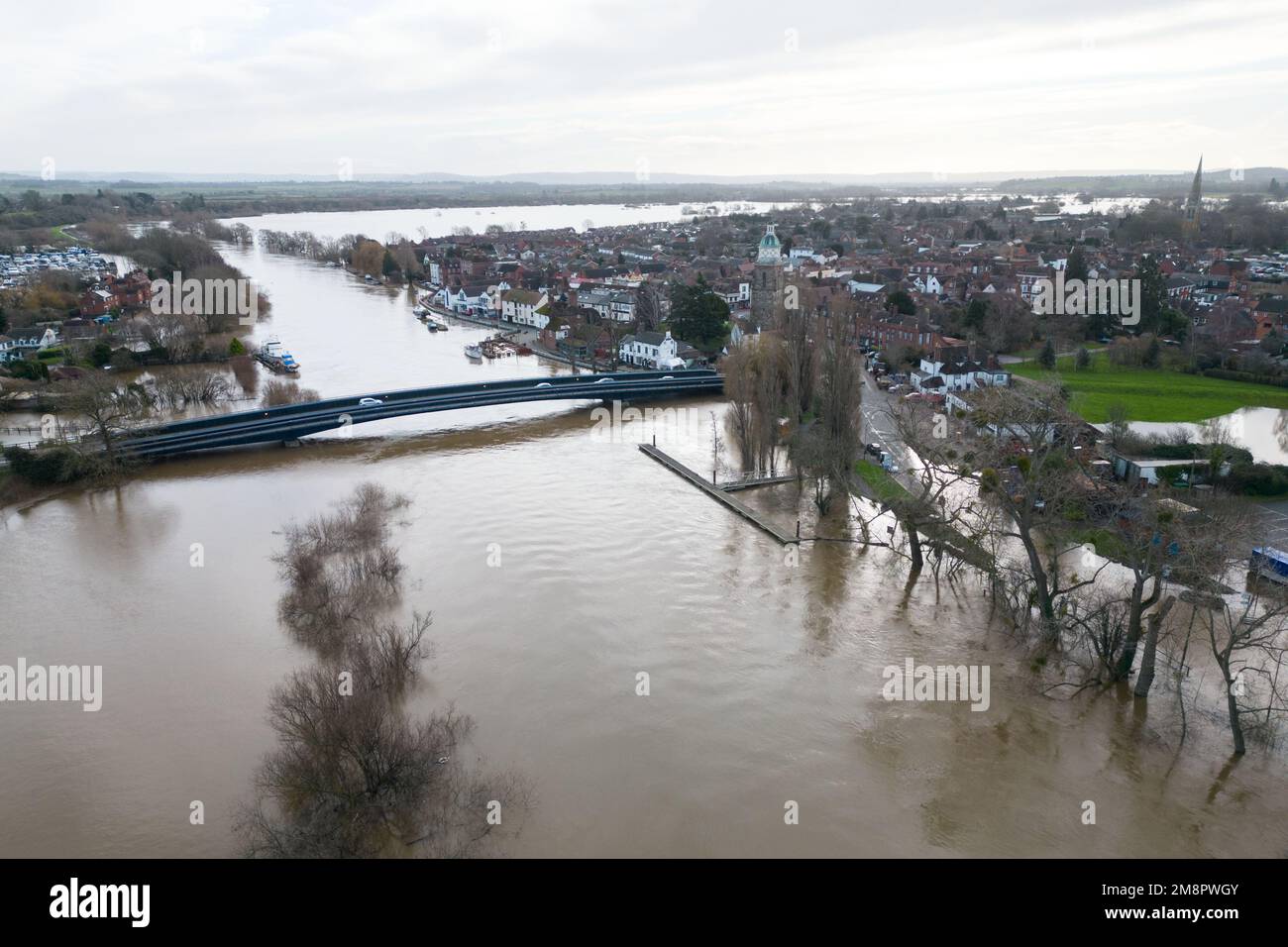 Upton upon Severn, Worcestershire, 15 janvier 2023 - la ville d'Upton-upon-Severn a presque été coupée avec seulement une route d'entrée et une route de sortie après que la rivière Severn a commencé à couler au-dessus des berges de rivière surélevées, inondant les champs environnants. Une station-service et un supermarché local Morrisons étaient devenus une île du déluge au-delà. Deux marcheurs ont été vus se frayant un chemin à travers des eaux peu profondes dans un champ fermier alors qu'ils promenaient leur chien. Crédit : arrêtez Press Media/Alamy Live News Banque D'Images