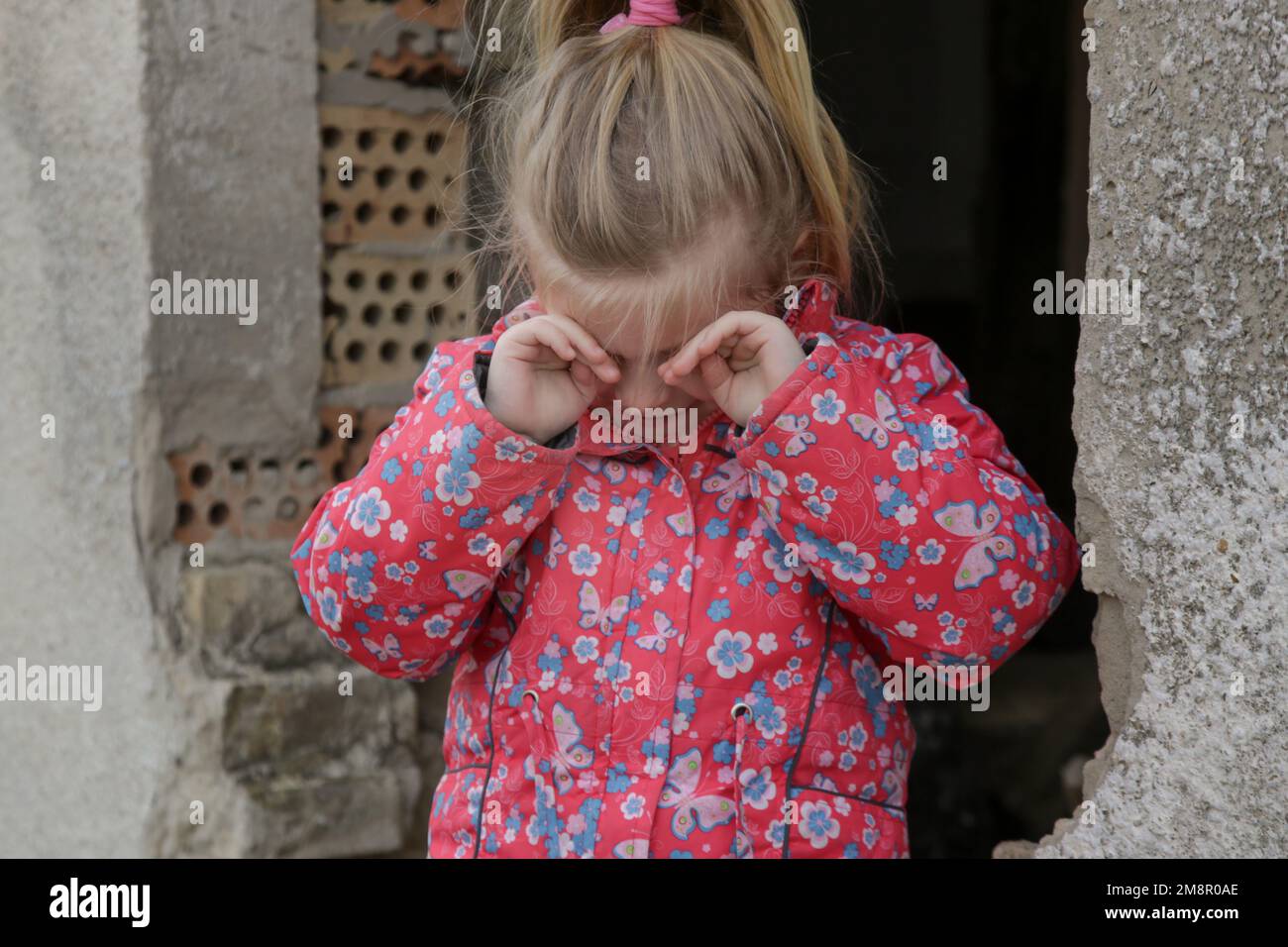 Portrait d'une petite fille triste dans un bâtiment en ruines. Réfugiés, crise de guerre, catastrophe humanitaire concept. Banque D'Images