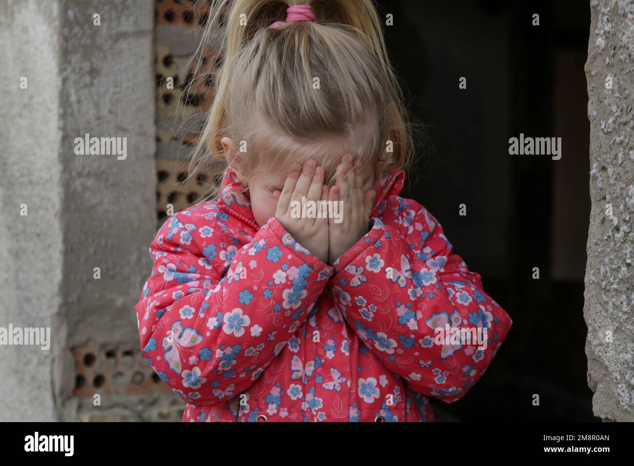 Portrait d'une petite fille triste dans un bâtiment en ruines. Réfugiés, crise de guerre, catastrophe humanitaire concept. Banque D'Images