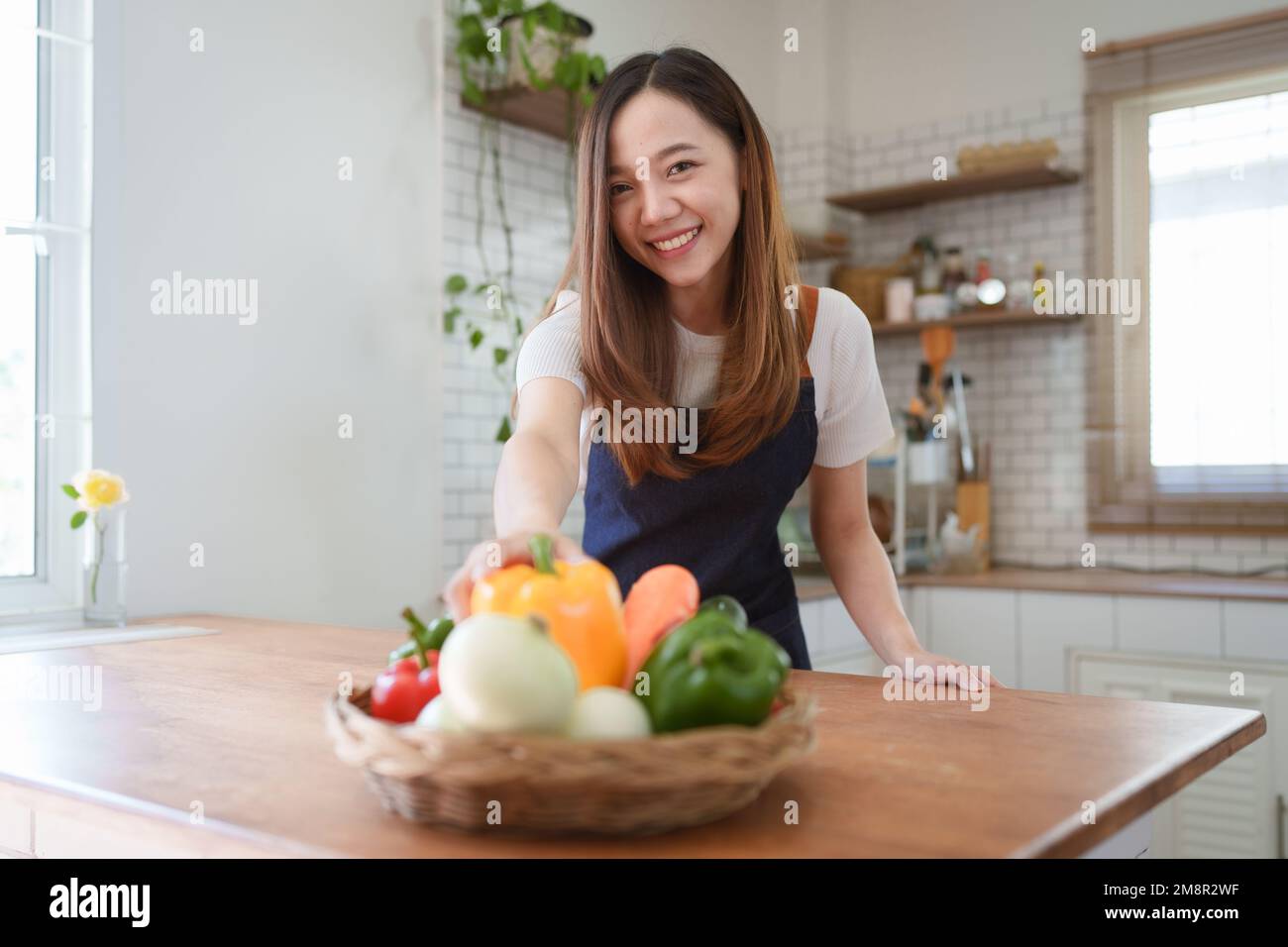 Portrait de la belle jeune femme asiatique faisant de la salade à la maison. Cuisiner des aliments et vivre des moments Banque D'Images