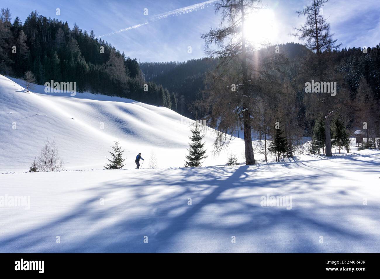 Paysage de montagne d'hiver en journée ensoleillée avec un seul skieur de fond dans la vallée de Filzmoos, Alpes de Salzbourg, Autriche, Europe. La neige couvre la vallée, b Banque D'Images