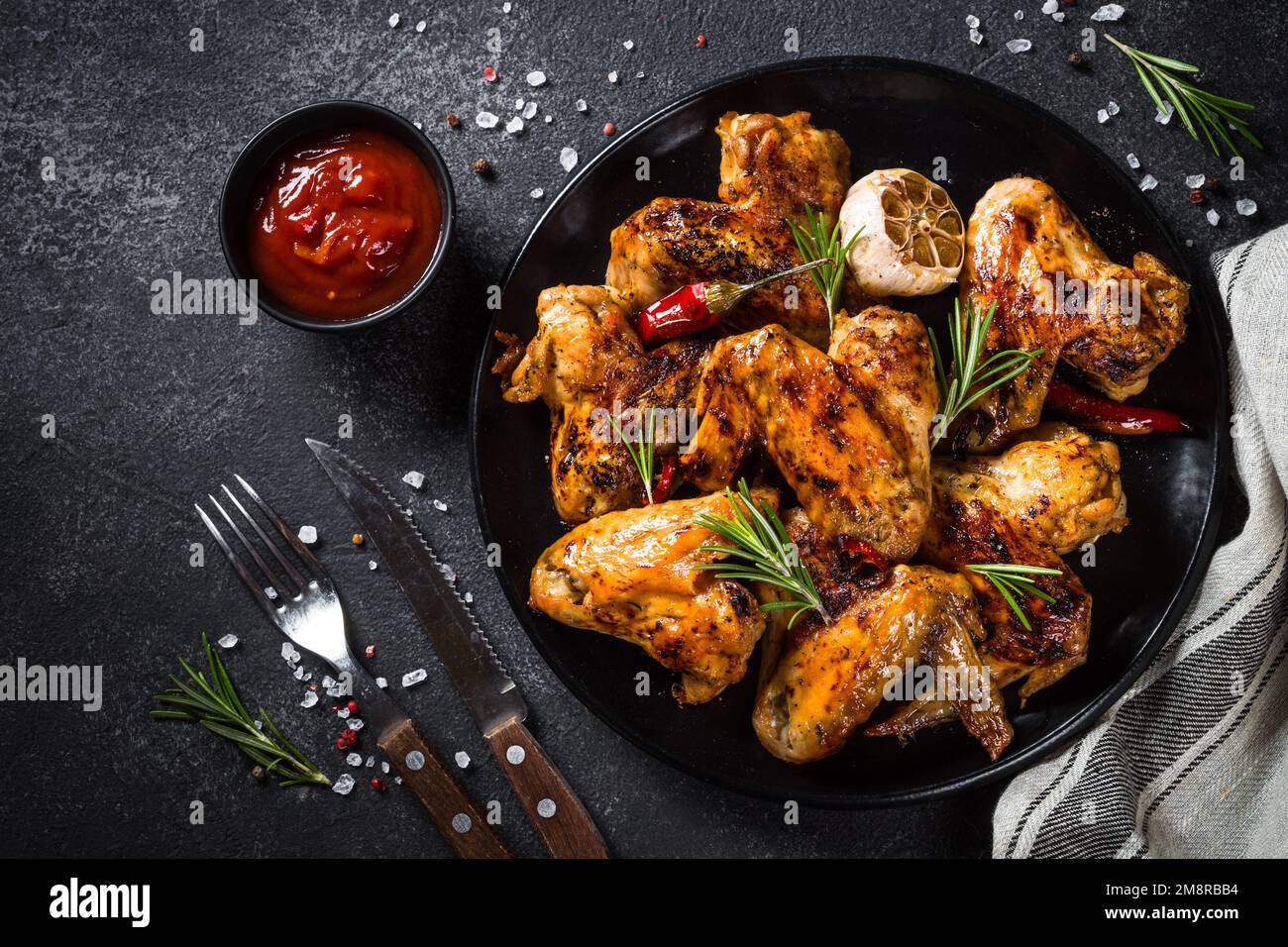 Ailes de poulet grillées aux épices à table noire. Vue de dessus avec espace pour le design. Banque D'Images