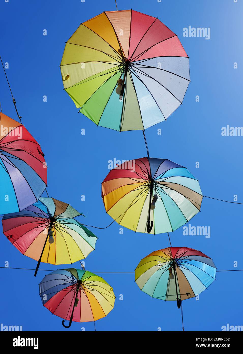 Parasols colorés pour la protection du soleil. Ciel bleu en arrière-plan. Couleurs arc-en-ciel. Banque D'Images