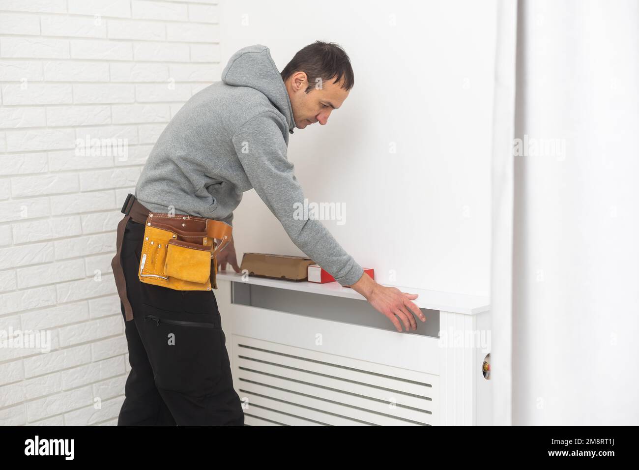 réparateur utilisant des outils lors de l'installation ou de la réparation du radiateur de chauffage. plombier d'installation du système de chauffage dans l'appartement. installation du radiateur, tuyauterie Banque D'Images
