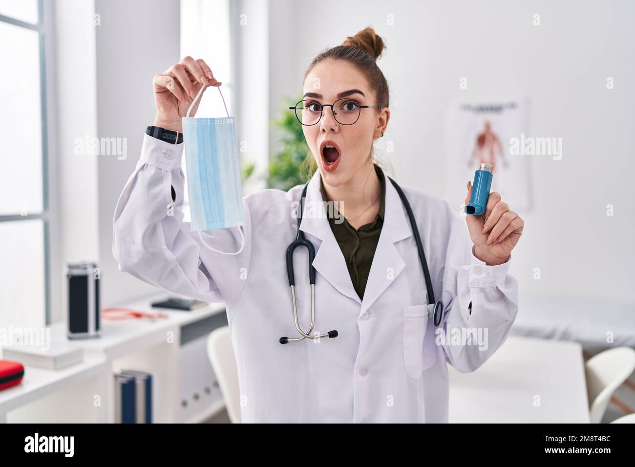 Jeune fille hispanique tenant un inhalateur d'asthme médical à la clinique  peur et choqué avec la surprise et l'expression stupéfaite, la peur et le  visage excité Photo Stock - Alamy