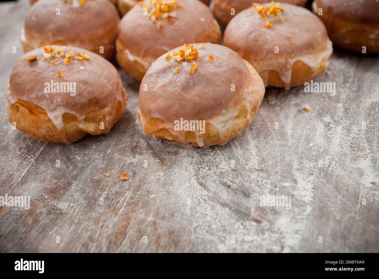 Gros jeudi. Photos de beignets avec garniture de cerise et glaçage. Beignets disposés sur un fond rustique. Banque D'Images