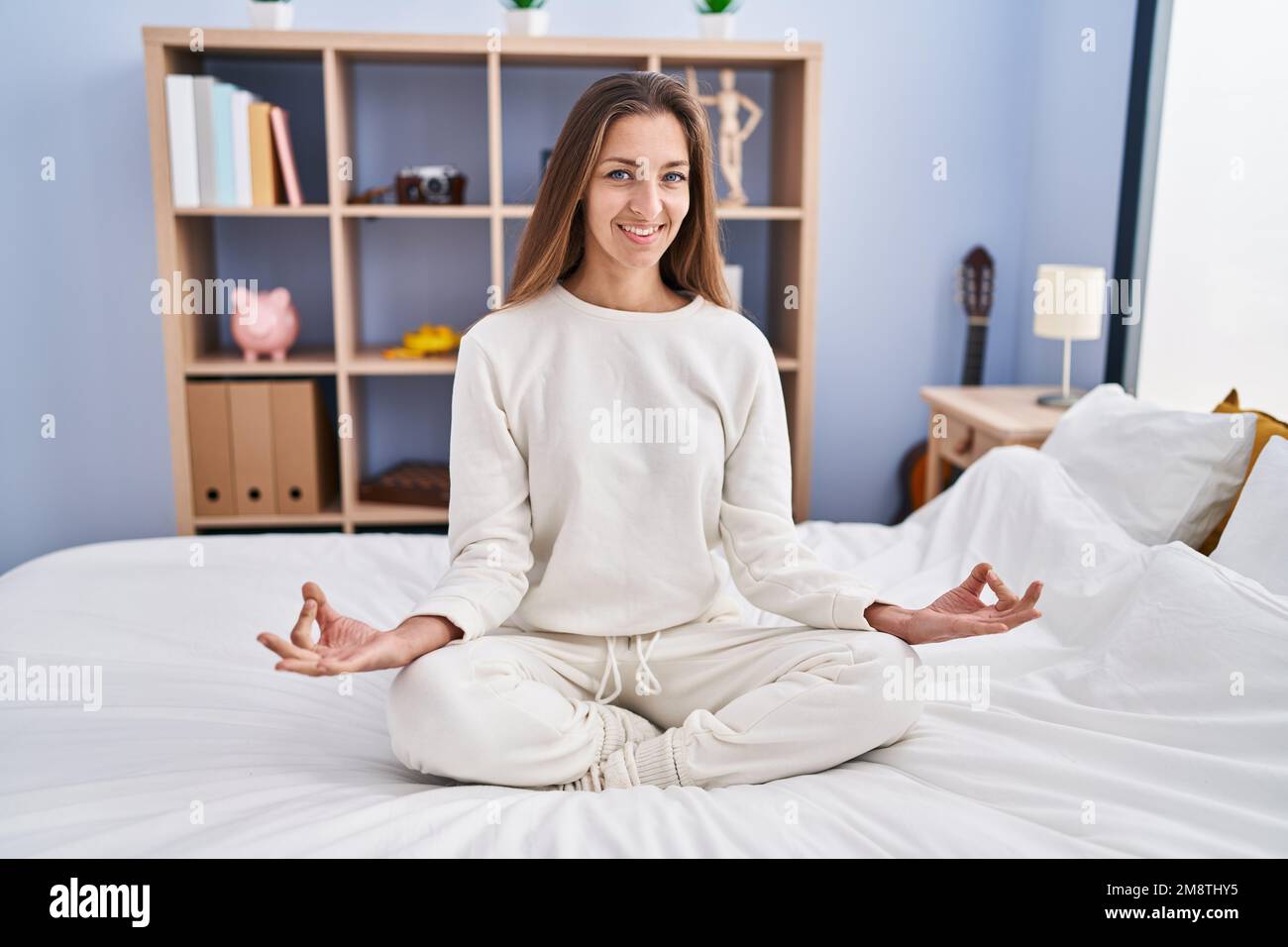 Jeune femme faisant de l'exercice de yoga assis sur le lit à la chambre  Photo Stock - Alamy