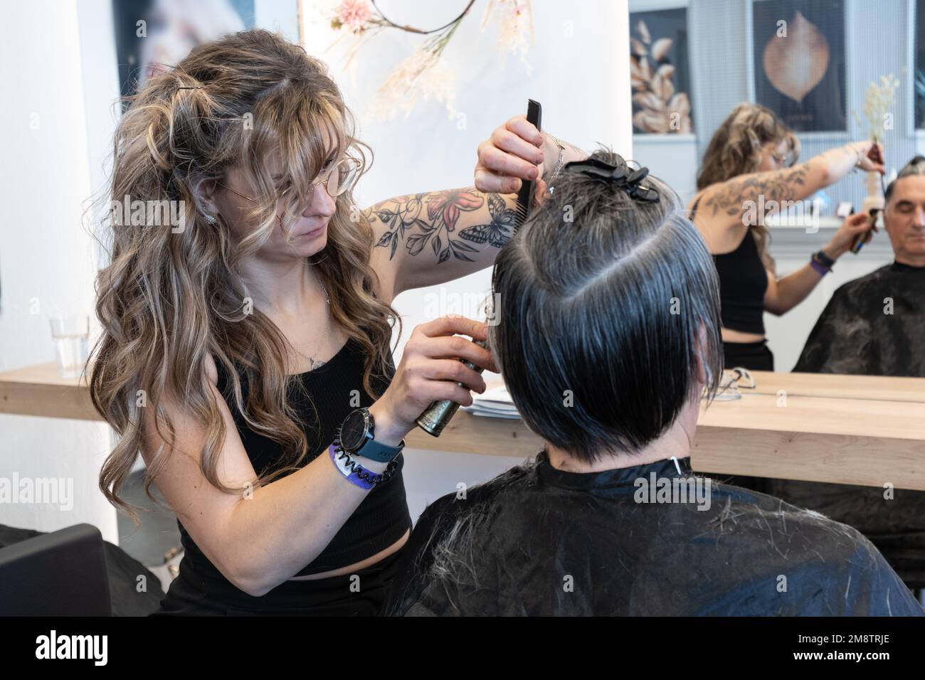 le coiffeur coupe de façon très nette la coupe de cheveux d'un homme âgé Banque D'Images