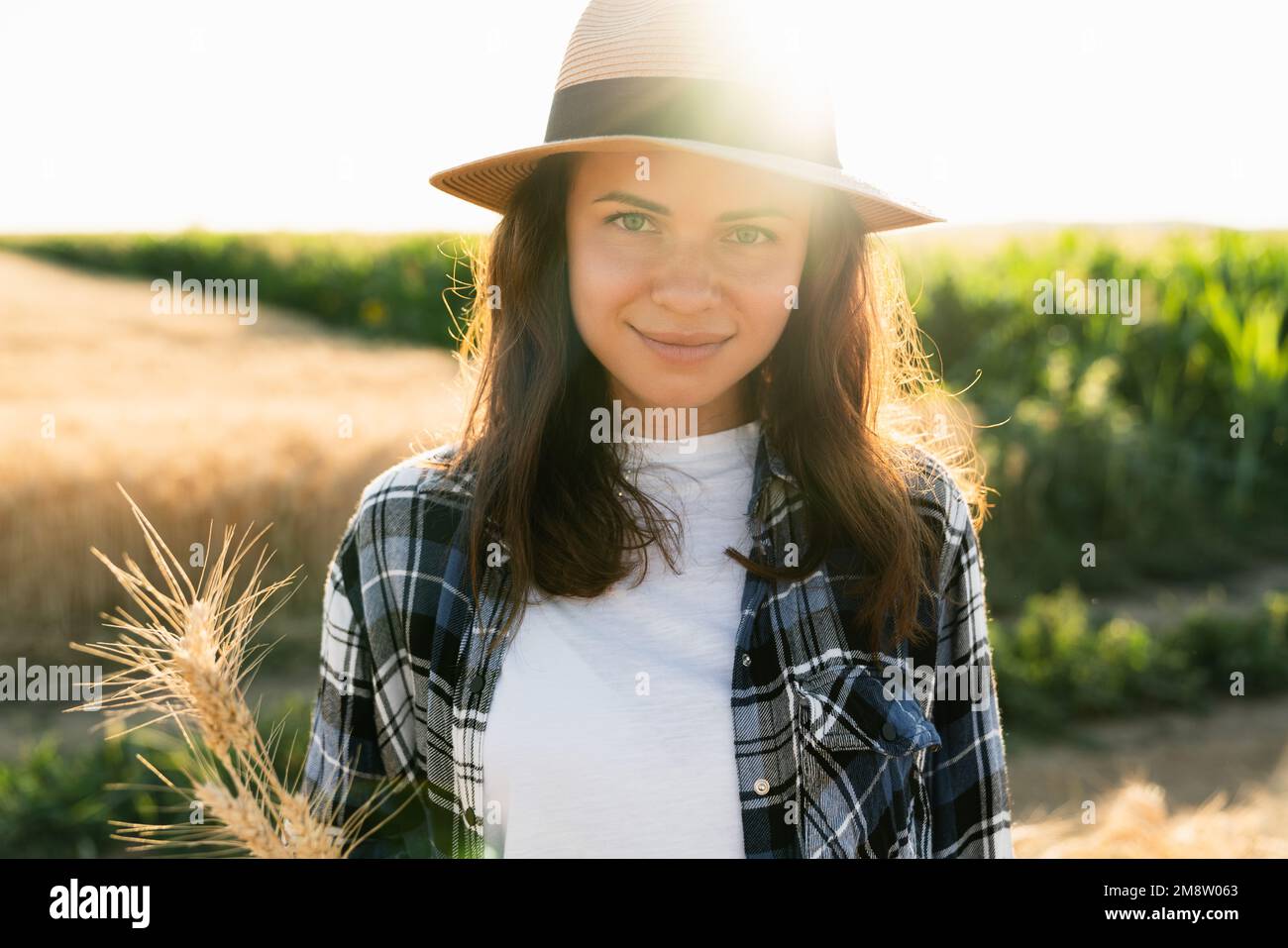 Portrait d'une femme dans un chapeau sur le fond d'un champ de coucher de soleil Banque D'Images