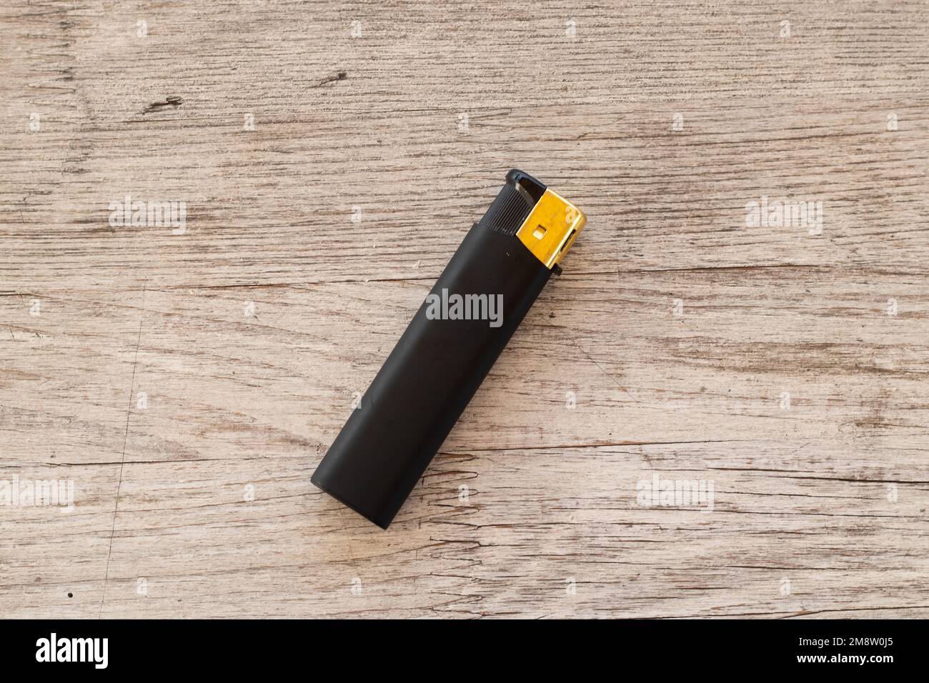 l'allume-cigare noir repose sur une table en bois Banque D'Images