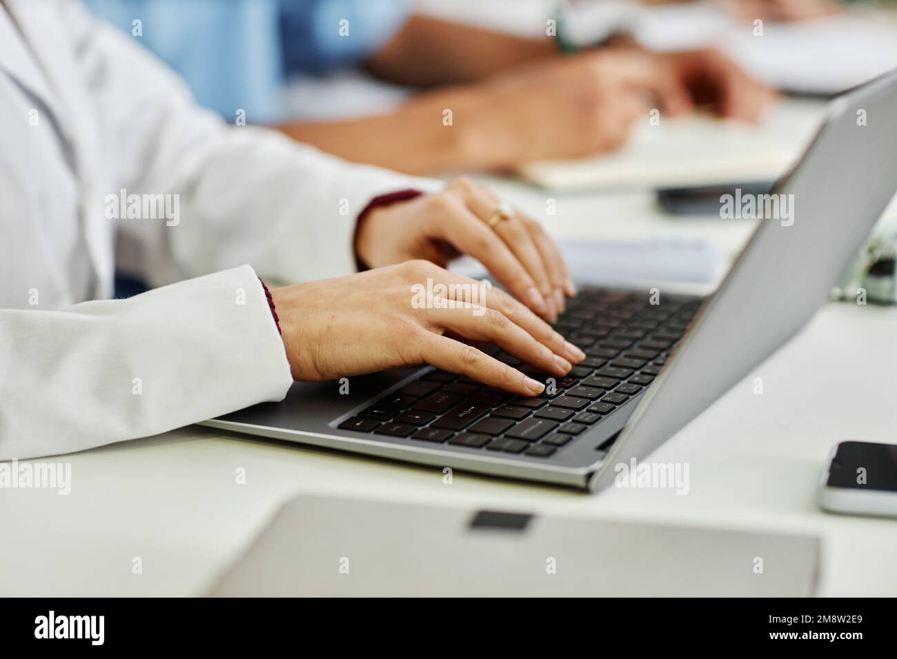 Gros plan de la jeune femme médecin dactylographiant sur le clavier de l'ordinateur portable pendant un séminaire médical ou un cours, espace de copie Banque D'Images