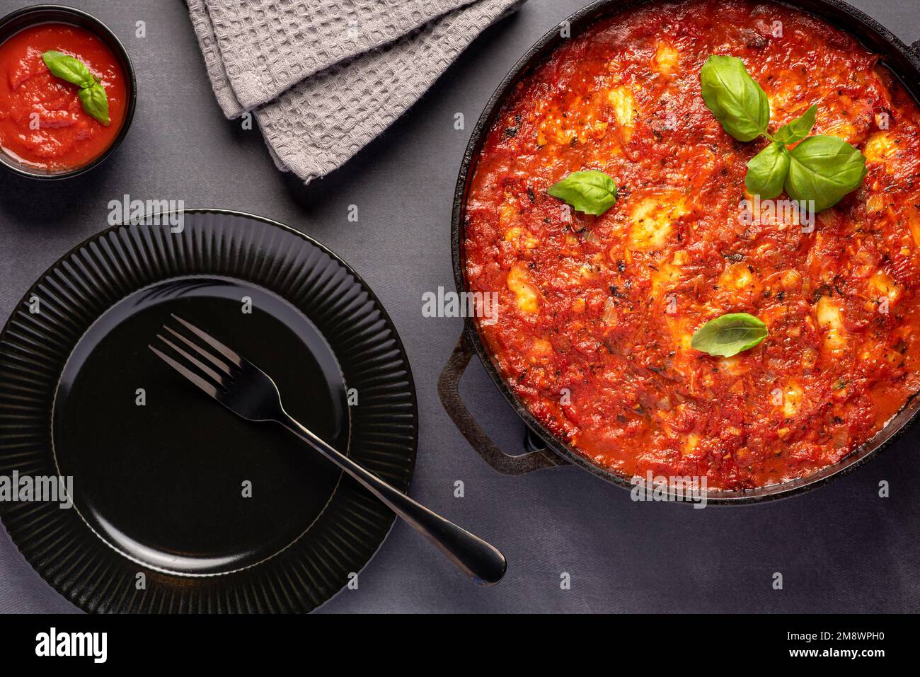 Photographie alimentaire de courgettes compochées, courgette, tomate, sauce, basilic, fromage, mozzarella, légumes, cocotte, ratatouille Banque D'Images