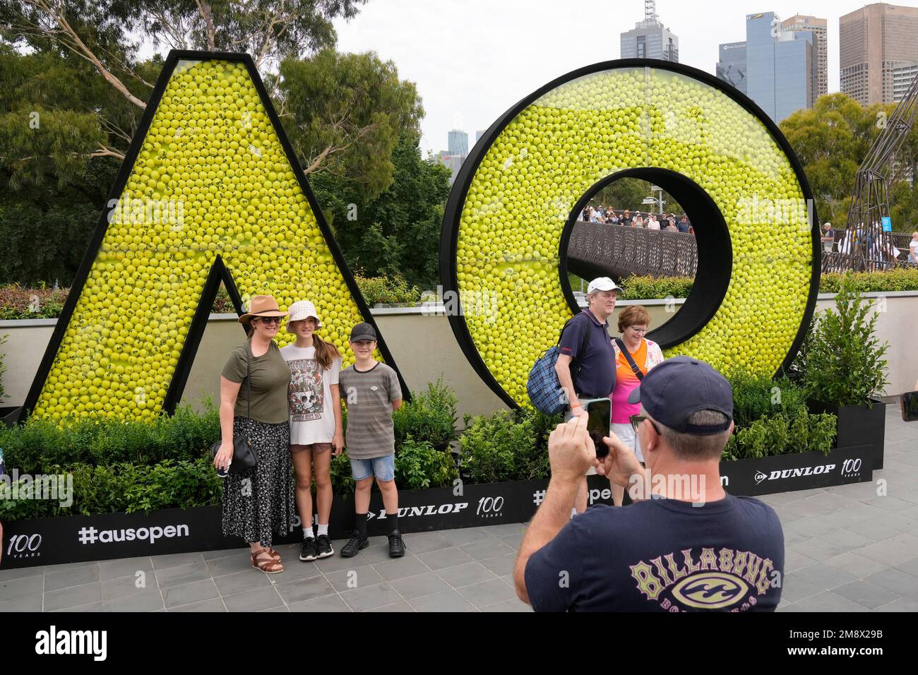 Fans pose for photos by Australian Open logos, ahead of play on one of the Australian Open tennis championship in Melbourne, Australia, Monday, Jan. 16, 2023. (AP Photo/Dita Alangkara) Banque D'Images