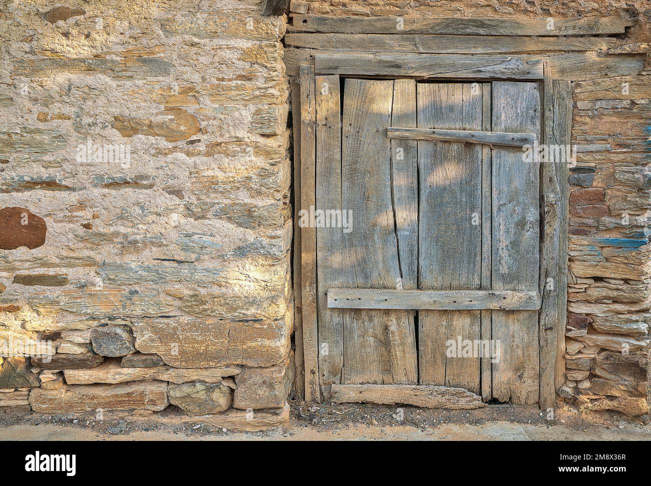 Porte rustique en bois sur le mur du bâtiment en adobe avec espace de copie Banque D'Images