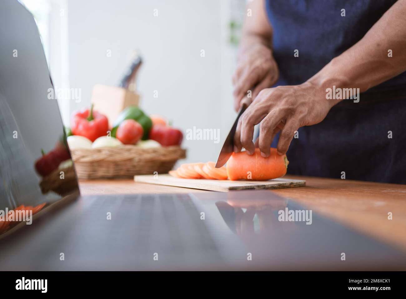 Portrait de l'homme asiatique faisant de la salade à la maison. Cuisiner des aliments et vivre des moments Banque D'Images