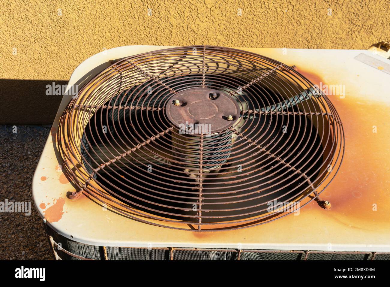 Machine de climatisation rouillée à l'extérieur du mur de stuc roc rouge Banque D'Images