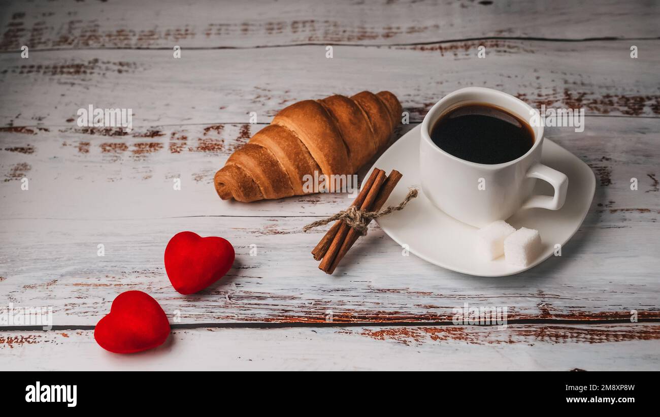 Tasse de café avec croissant et coeurs sur table en bois. Concept du — free download