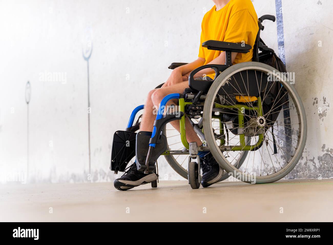 Détail d'une personne handicapée dans un fauteuil roulant à une fronton de jeu de pelota basque Banque D'Images