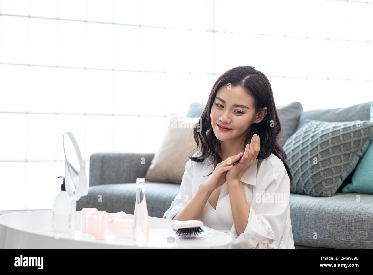 Le soin des cheveux de la jeune femme Banque D'Images