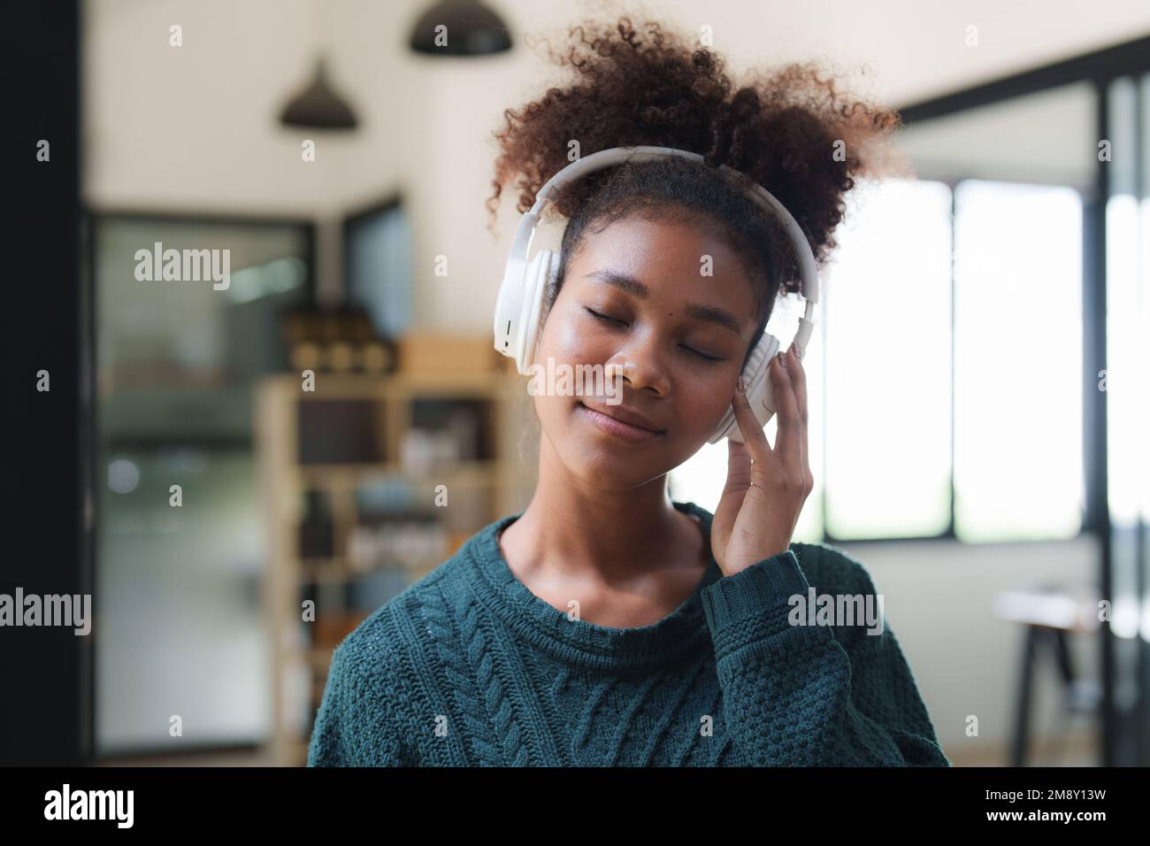 Jeune femme noire écoutant de la musique en ligne, portant des