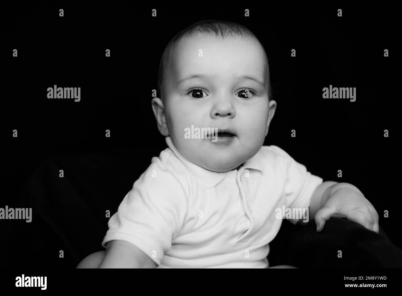 Portrait noir et blanc de drôle petit enfant mignon. Bébé caucasien regardant l'appareil photo Banque D'Images