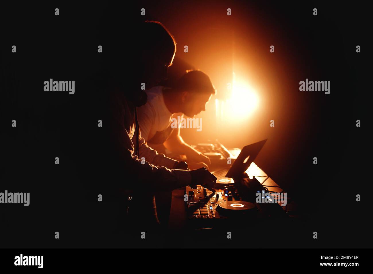 Silhouette de DJ jouant le mélangeur sur scène lors d'une fête dans une discothèque Banque D'Images