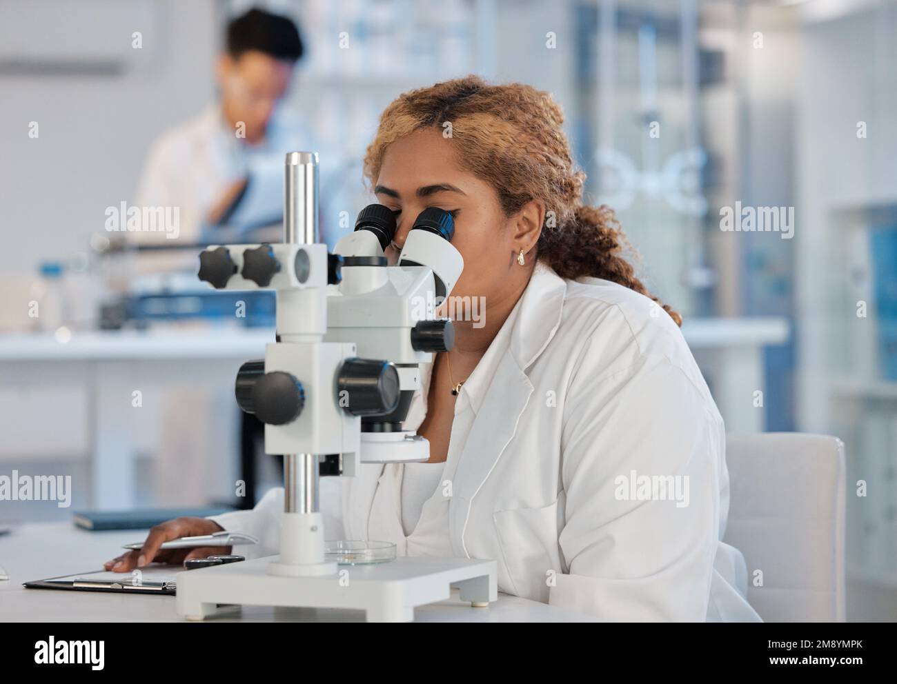 Il y a toujours quelque chose d'excitant à attendre. une jeune travailleuse de laboratoire qui analyse des échantillons au microscope. Banque D'Images