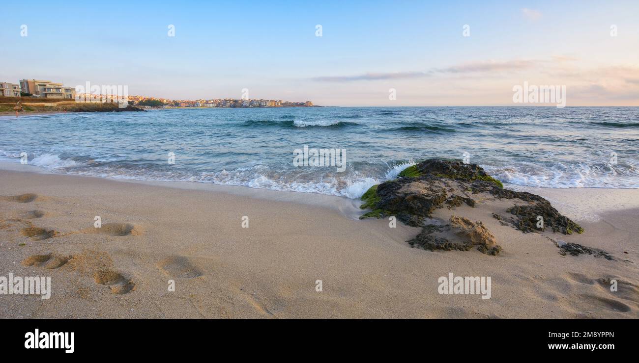 en pierre sur le rivage sablonneux de la mer. saison des vacances d'été. voyagez en arrière-plan avec des humeurs au-dessus de l'horizon Banque D'Images