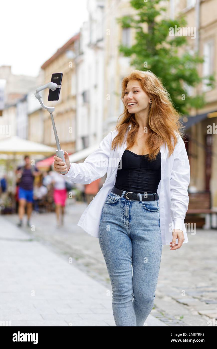 Jeune femme rechapée à pied et en utilisant son téléphone portable Banque D'Images