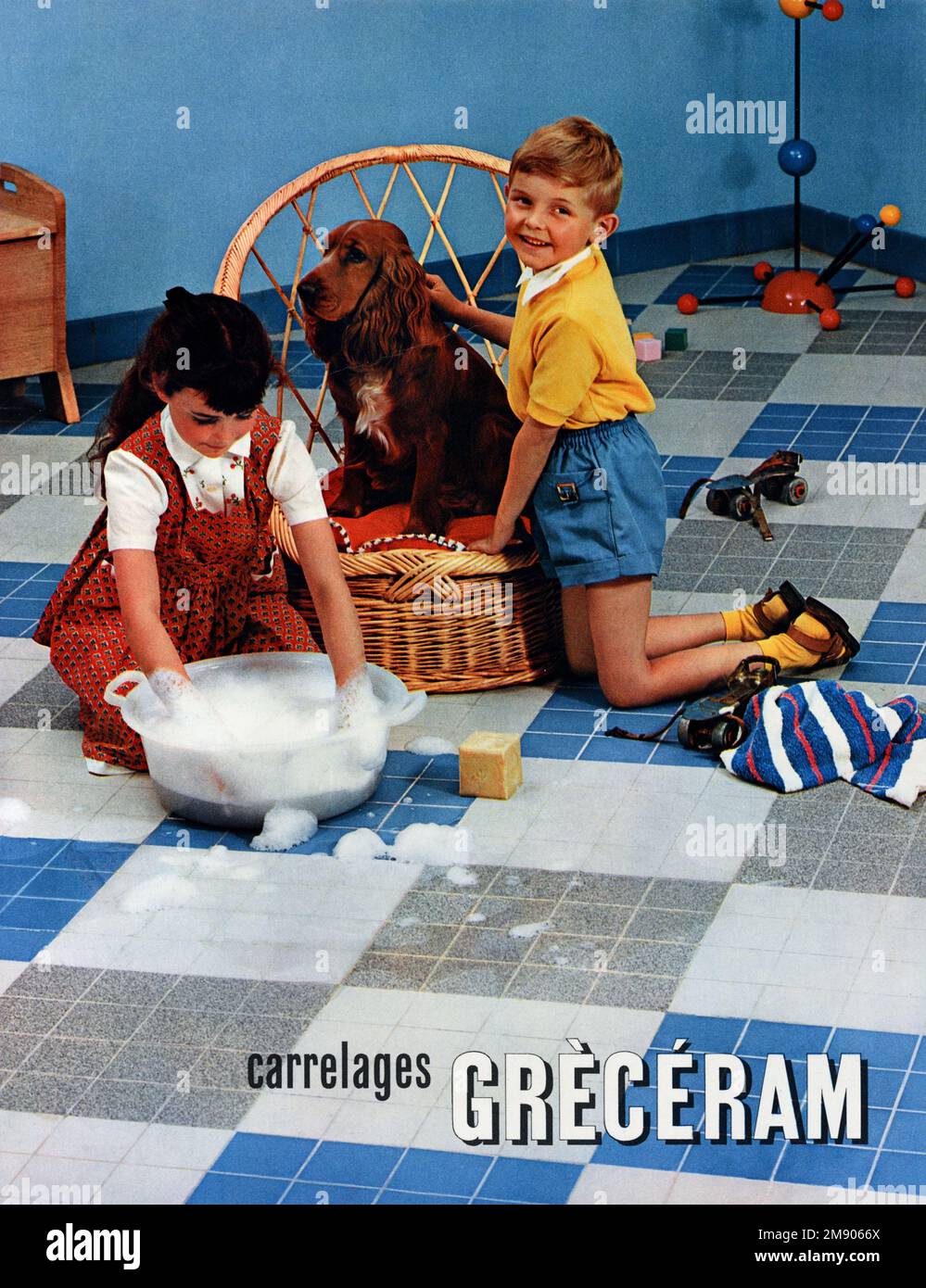 Publicité pour 1950s carreaux de sol Greceram avec enfants et chien d'Espagne en 1950s intérieur. Publicité, publicité, publicité ou Illustration vintage ou ancien 1957 Banque D'Images