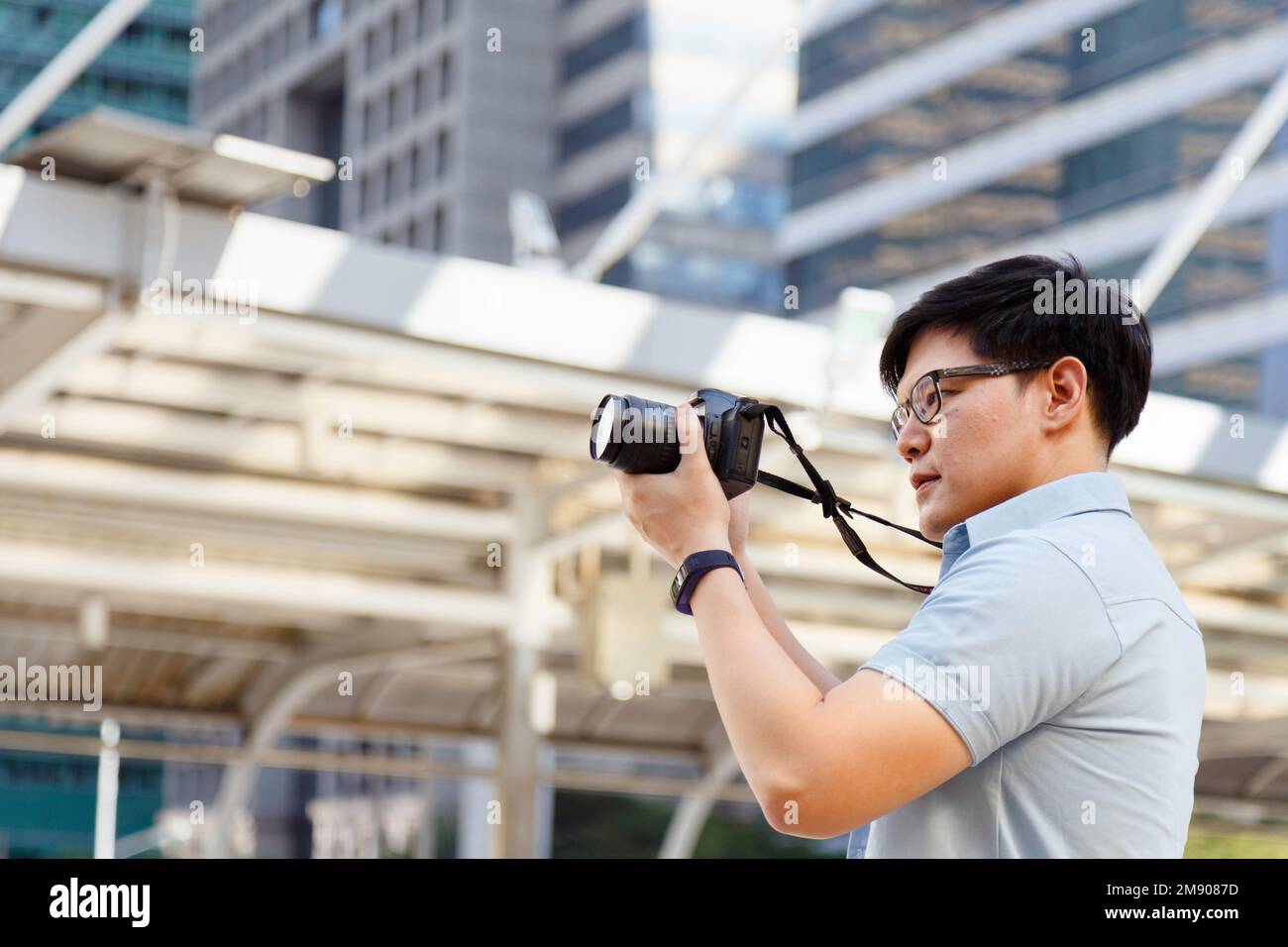 Jeune photographe asiatique tenant l'appareil photo pour prendre des photos de la ville. Plein air été style de vie portrait voyageur s'amusant avec la rue de tournage Banque D'Images