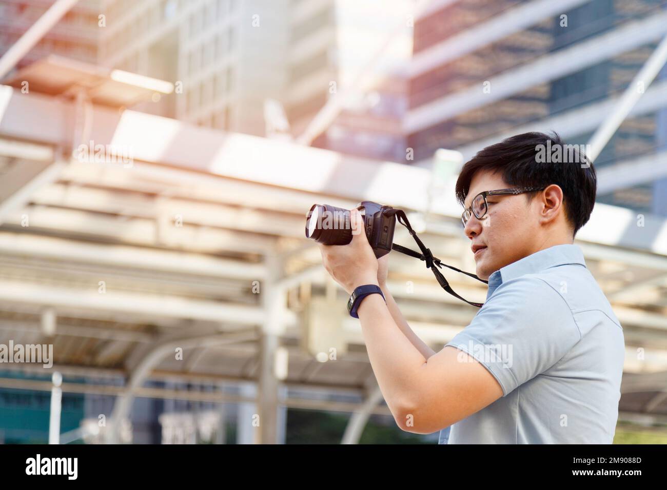 Jeune photographe asiatique tenant l'appareil photo pour prendre des photos de la ville. Plein air été style de vie portrait voyageur s'amusant avec la rue de tournage Banque D'Images