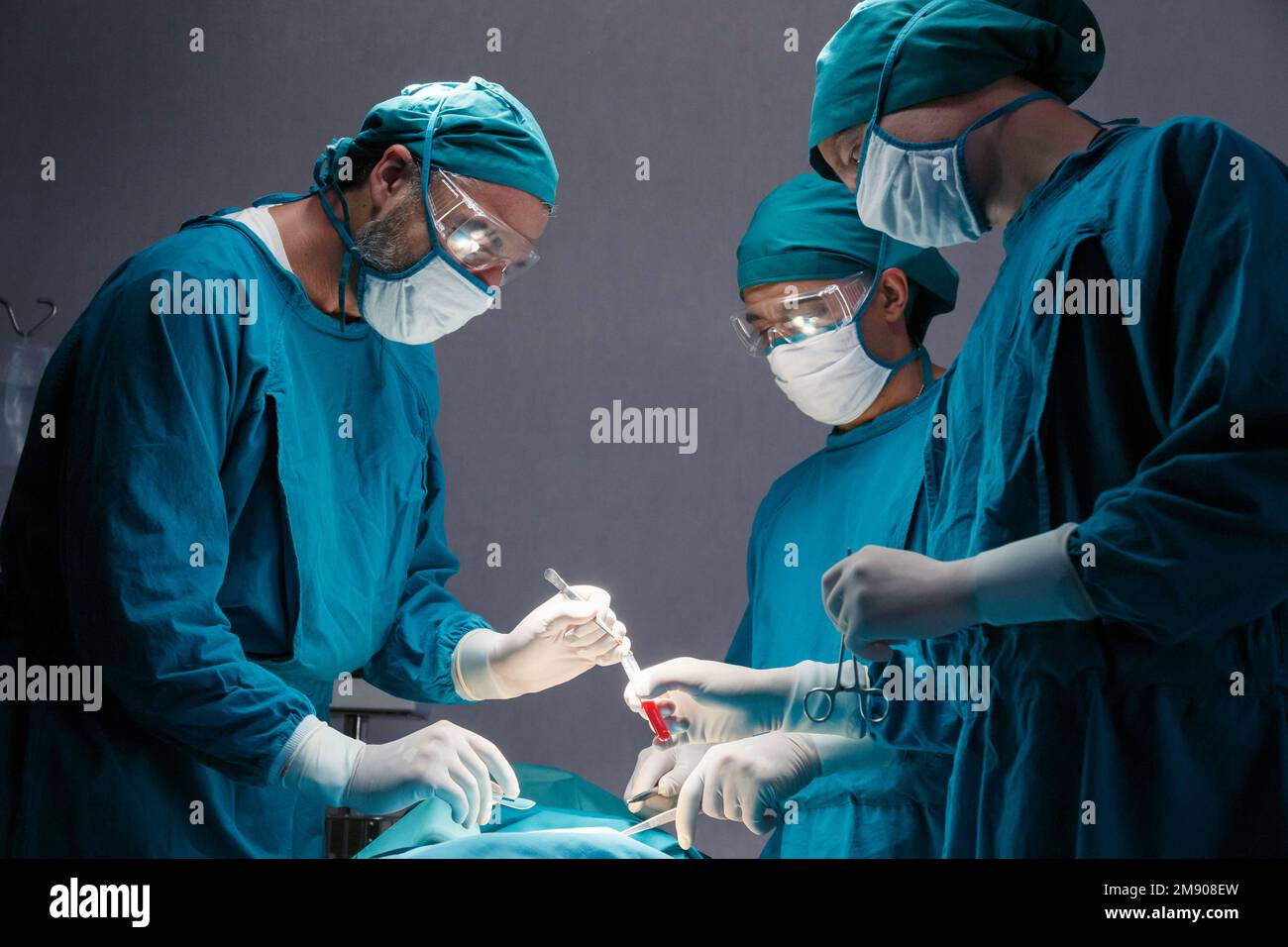 groupe de médecins chirurgicaux professionnels concentré chirurgie chirurgicale un patient dans la salle d'opération de l'hôpital. concept médical et de soins de santé. Banque D'Images