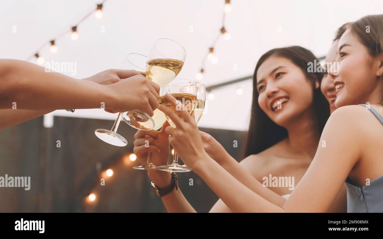 femme asiatique ados applaudissent et toast avec un verre de vin blanc mousseux à célébrer à dîner partie en été. célébration, relation et f Banque D'Images