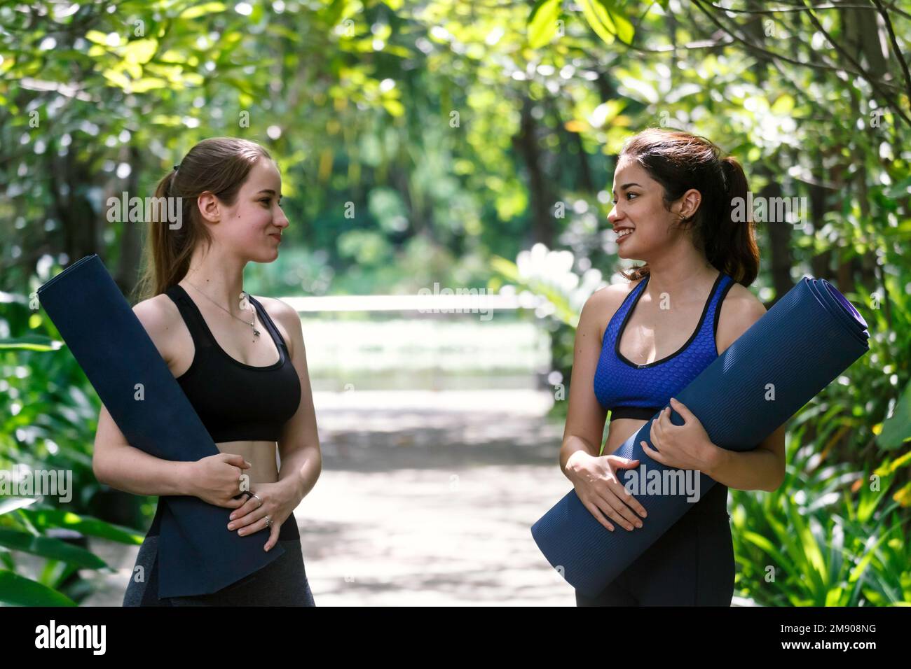 portrait heureux beau deux femmes adolescentes amis parlant dans le parc après l'exercice de yoga. l'amitié et le style de vie des gens Banque D'Images