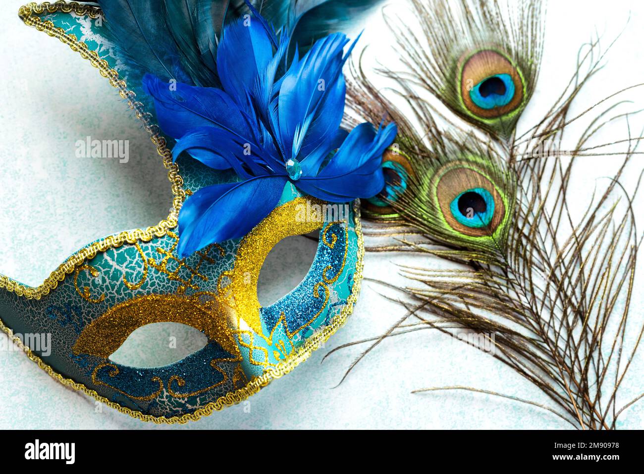 Masque de carnaval vénitien et plumes de paon sur fond bleu. Concept de célébration du Carnaval Banque D'Images