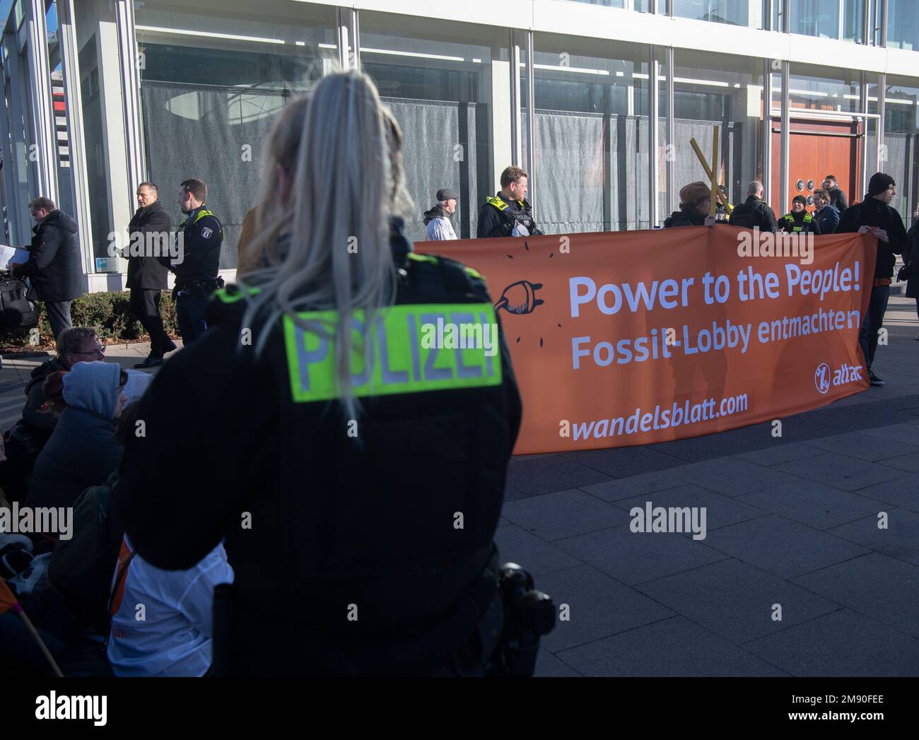 Berlin, Allemagne. 16th janvier 2023. Les militants Attac bloquent le Centre des congrès de Berlin (BCC) avec une bannière en présence d'agents de police. Un sommet énergétique du Handelsblatt avec des représentants des entreprises et de la politique y a lieu: Le pouvoir au peuple: Attac discute de l'énergie de l'avenir. Entre autres choses, les activistes exigent une socialisation de l'industrie de l'énergie. Credit: Paul Zinken/dpa/Alay Live News Banque D'Images