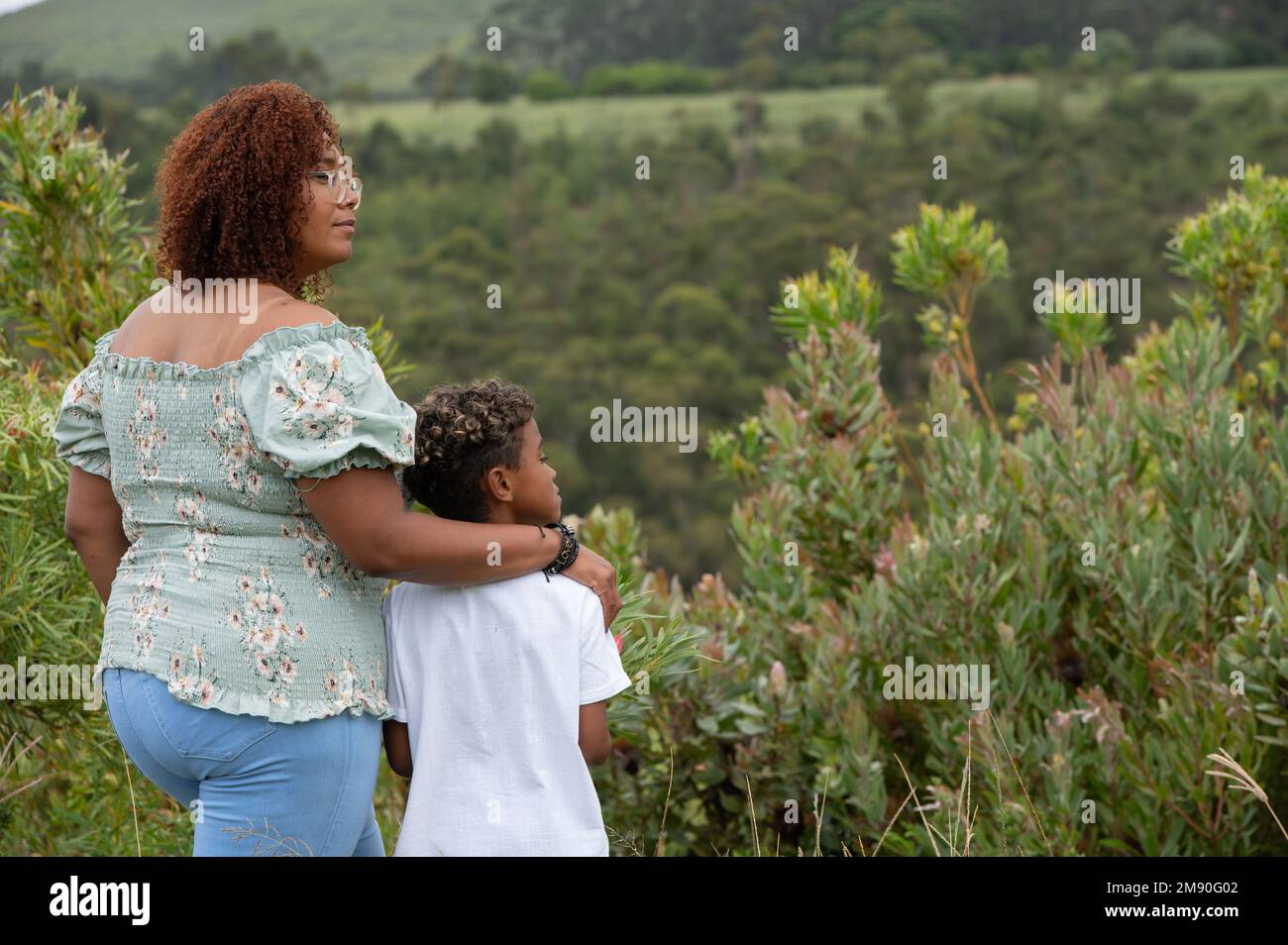 Vue arrière de maman et fils debout à l'extérieur Banque D'Images