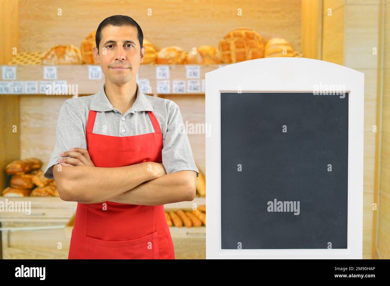 Portrait d'un homme travaillant dans une boulangerie avec tableau noir Banque D'Images