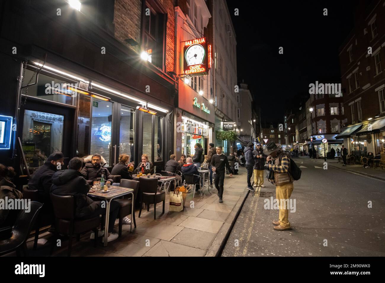Les gens s'assoient devant un café/bar à Soho, le long de Greek Street, la nuit, dans le West End de Londres, en Angleterre, au Royaume-Uni Banque D'Images