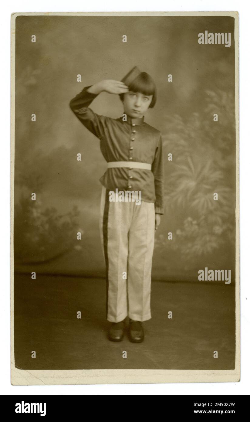 Carte postale originale des années 1930 d'une jeune fille mignonne vêtue de l'uniforme d'une fanfare de jeunesse, fanfare militaire. l'enfance des années 1930. fille des années 1930. l'enfant des années 1930. les enfants des années 1930. Elle porte un pantalon en soie, une tunique et un chapeau de chasseur et salue. La carte postale est datée du 6 janvier 1934 au verso, studio de Williams Pioneers Studios Ltd. Tooting, Kingsland, Deptford, Londres. Banque D'Images