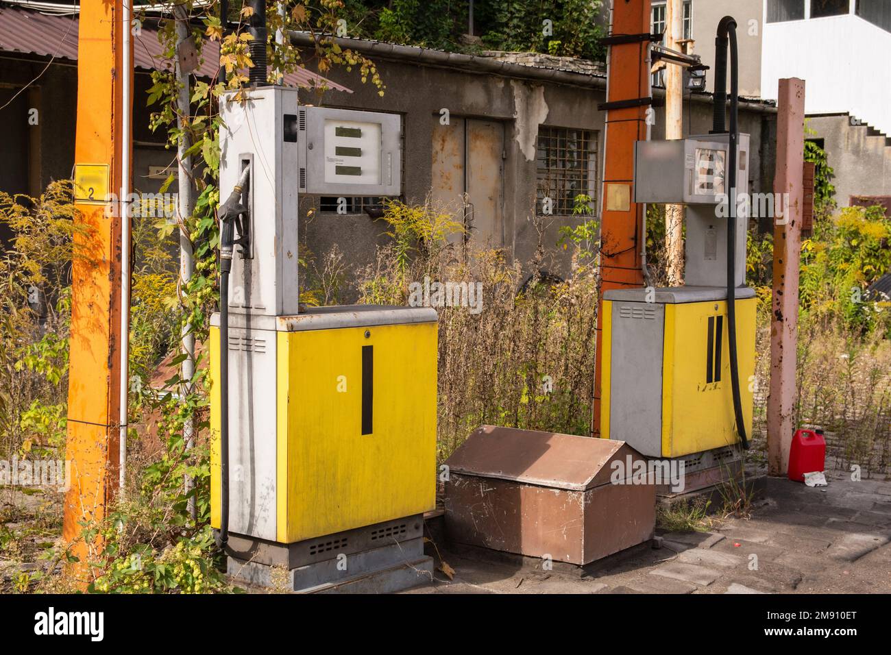 Une ancienne station de gaz rouillé et des distributeurs abandonnés et surcultivés avec de la végétation par une journée ensoleillée. Été. Banque D'Images