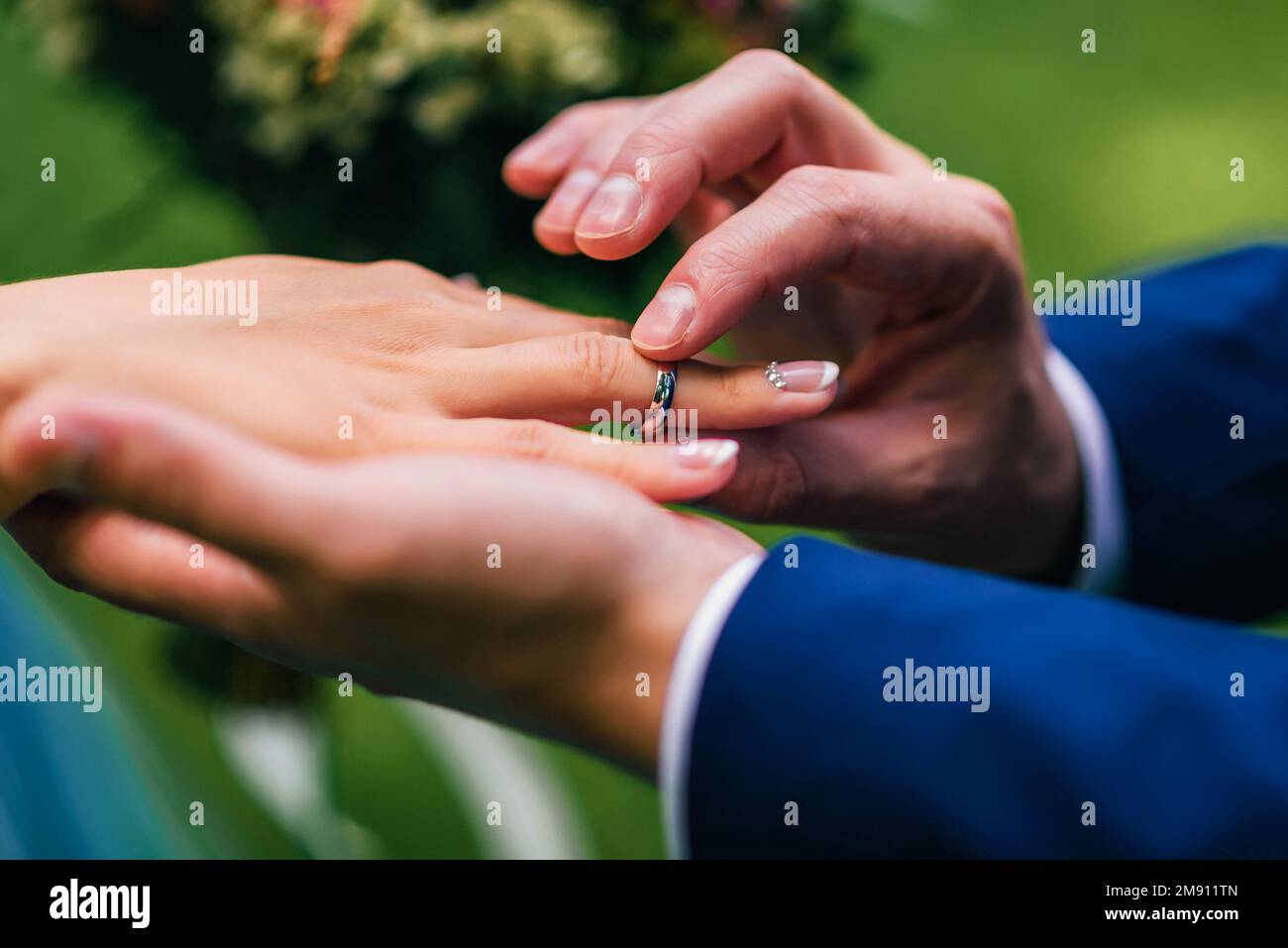 marié met la mariée un anneau de mariage d'or blanc sur son doigt. Gros plan sur les anneaux échangeant les mains lors de la cérémonie Banque D'Images