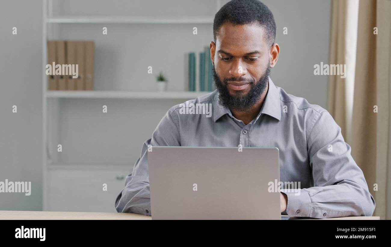L'ethnie afro-américaine perde des hommes d'affaires travaillent en ligne avec l'ordinateur dans le bureau. Homme d'affaires employeur gestionnaire travailleur cadre chef de la direction entrepreneur Banque D'Images