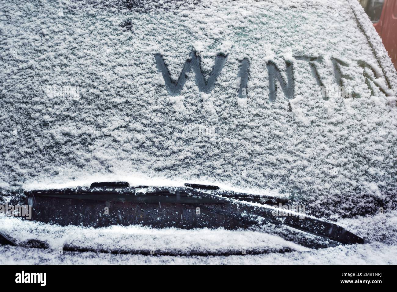 Un hiver écrit sur le pare-brise d'une voiture en hiver par temps neigeux Banque D'Images