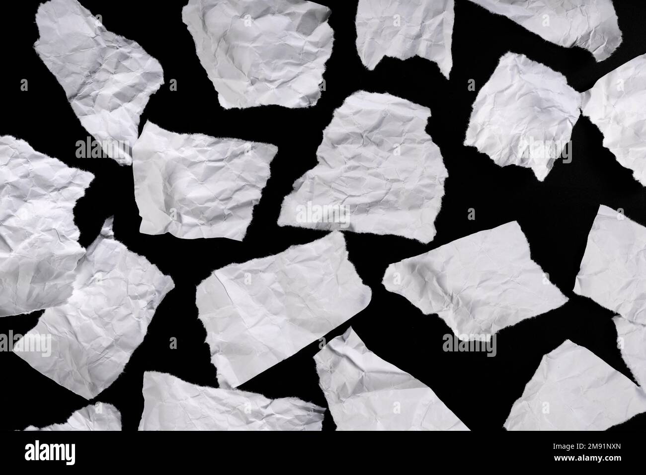 Morceaux de papier déchiré, pour message sur fond noir Banque D'Images