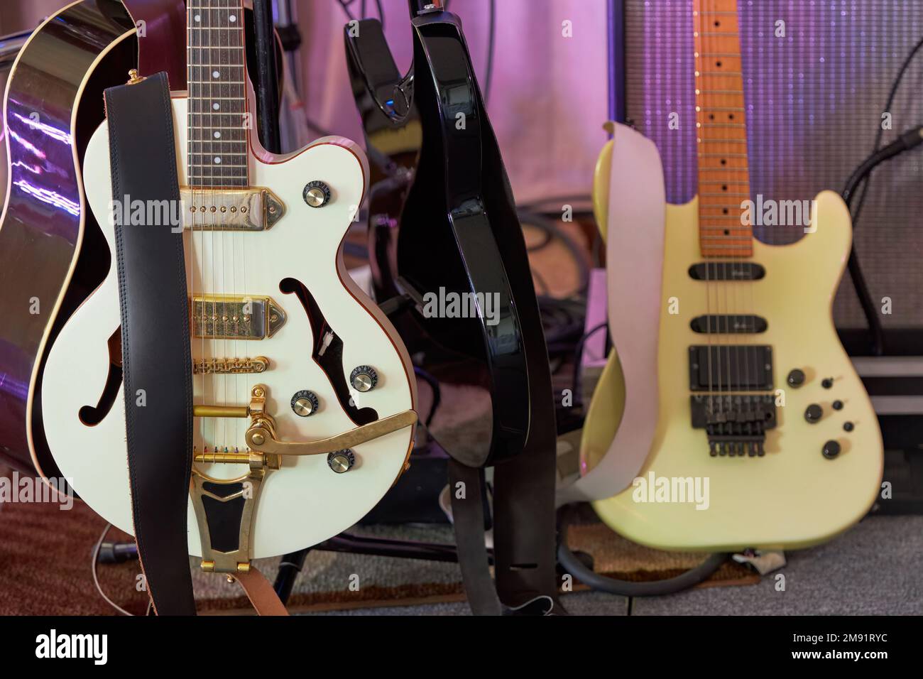 Gros plan des guitares électriques et acoustiques sur les stands avant un spectacle de scène Banque D'Images