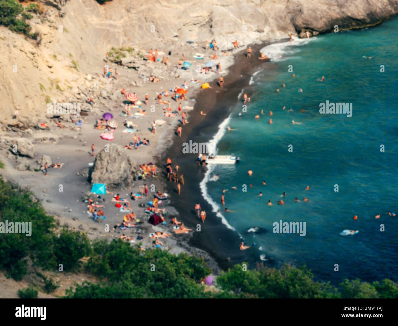 les gens se détendent, prennent le soleil et nagent dans la mer sur la plage de sable la vue du dessus floue hors de focus Banque D'Images